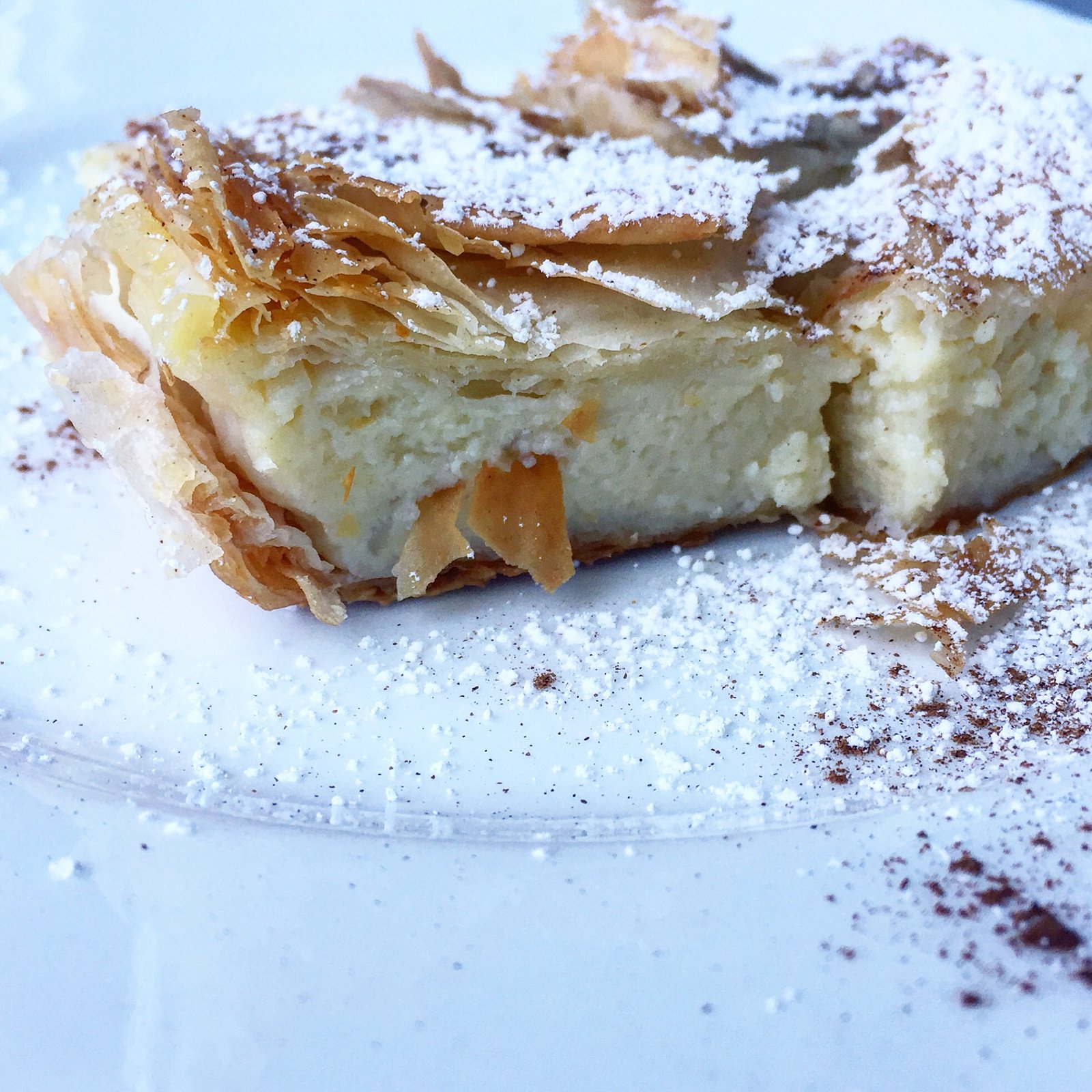 a piece of bougatsa served with cinnamon & powdered sugar.