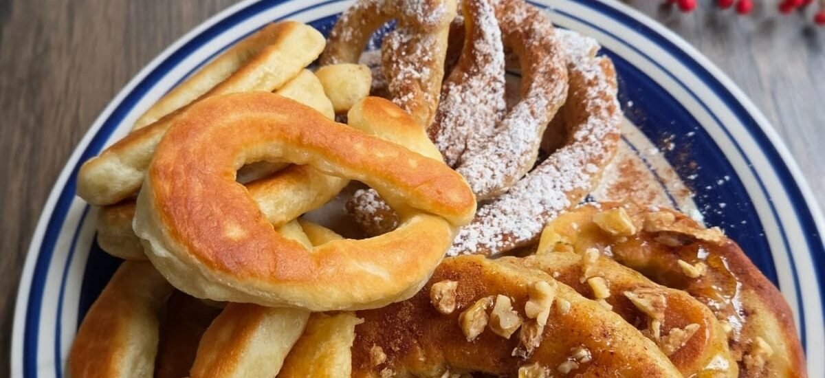 Lalagia served on a plate with powdered sugar, honey, and cinnamon.