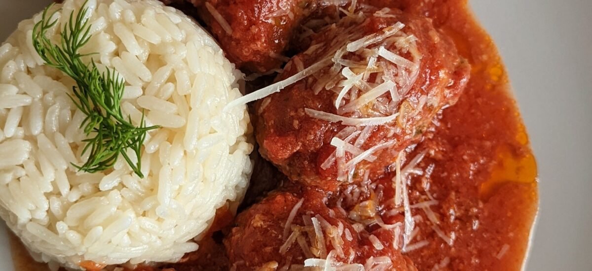 A photo of our Greek meatballs with tomato wine sauce and cheese.