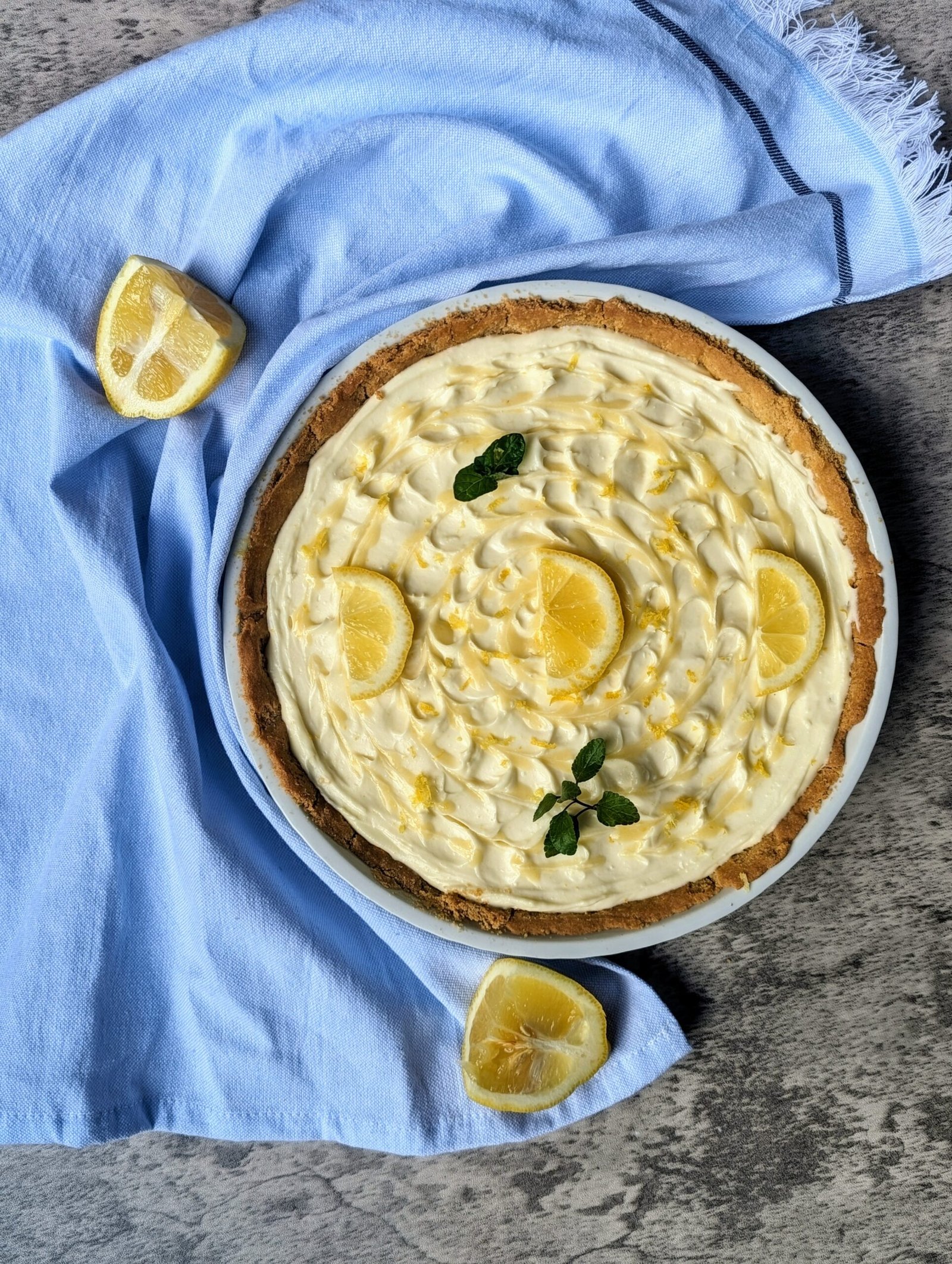 a photo of our lemon pie with lemon wedges and mint.