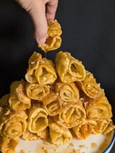 diples served on a blue and white plate and a hand picking one up